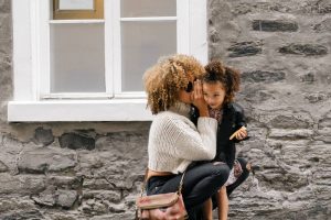 Mother wispering something to her daughter.