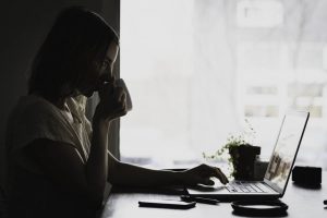 What is a binding estimate? A woman typing something on a laptop and drinking from the cup.
