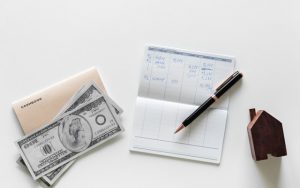 Money beside a paper and pen