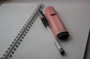 A notebook, pencil, and a marker