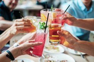 Manos con diferentes bebidas.
